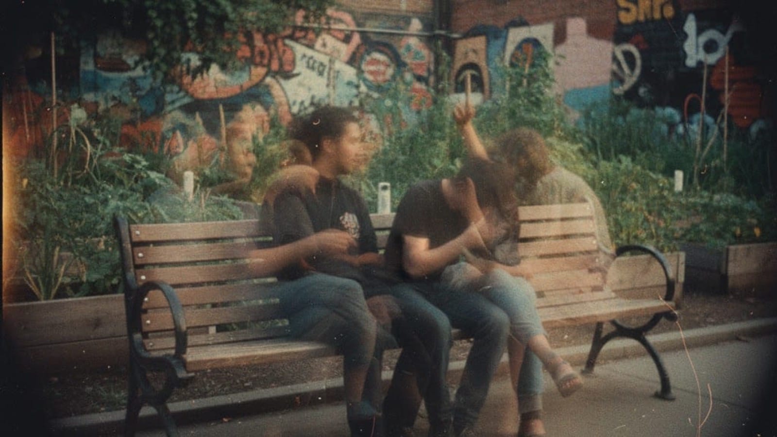 Three people in conversation on a park bench in a community garden, shot on vintage film with natural motion blur - the moment public infrastructure becomes living community