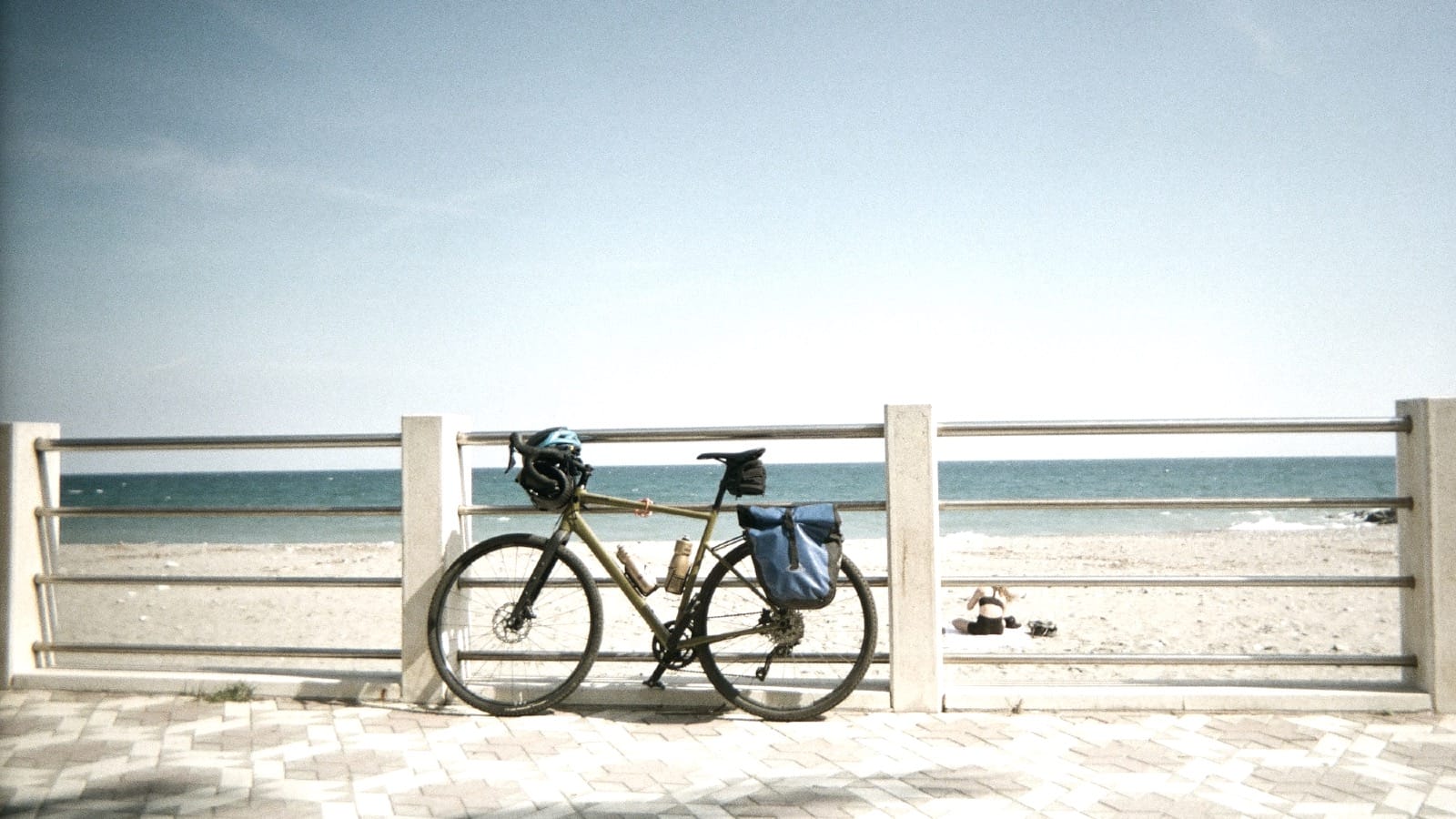 Bicycle leaning against white beach railing with ocean view, representing operational infrastructure that exists but sits idle until diagnostic work reveals performance barriers