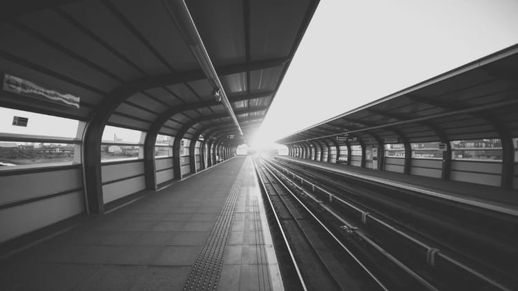 Empty transit platform with parallel tracks and sunlight ahead, representing multiple channel options requiring strategic selection based on audience discovery behavior