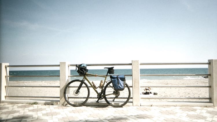 Bicycle leaning against white beach railing with ocean view, representing operational infrastructure that exists but sits idle until diagnostic work reveals performance barriers
